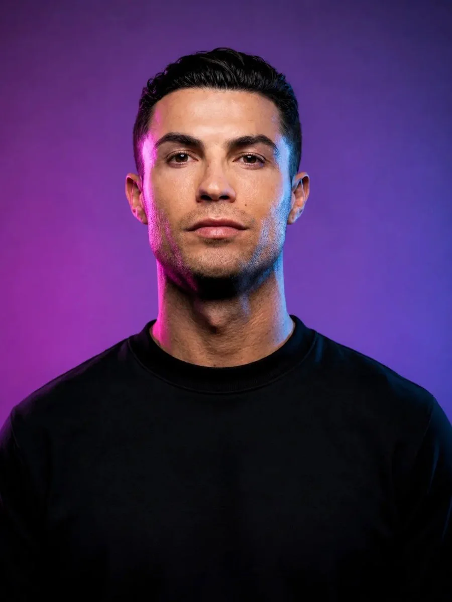 A centered photorealistic male head-and-shoulders portrait in a black shirt with dramatic two-tone pink and blue studio lighting on a purple-blue backdrop.